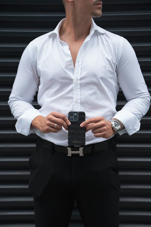 Free Handsome Man Holding an iPhone 15, 14, 13 Case by GENTCREATE Stock Photo