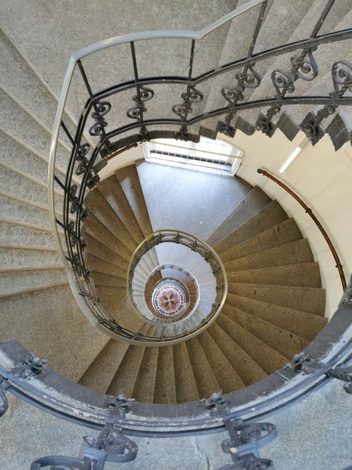 Free A top-down view of a spiral staircase showcasing intricate railing details. Stock Photo