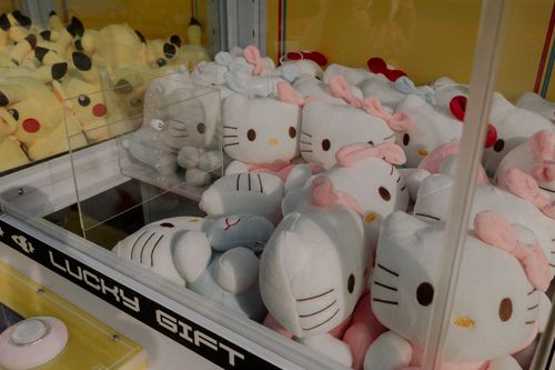 Free Claw machine featuring plush Hello Kitty and Pikachu toys, ideal for arcade entertainment. Stock Photo