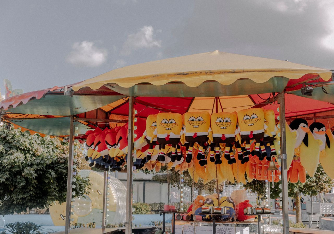 a vibrant fairground stall with plush toys including popular character