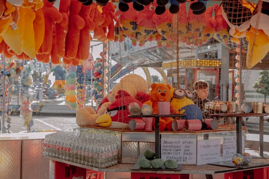 Carnival stall with plush toys and prizes on display, attracting visitors with fun and vibrant colors.