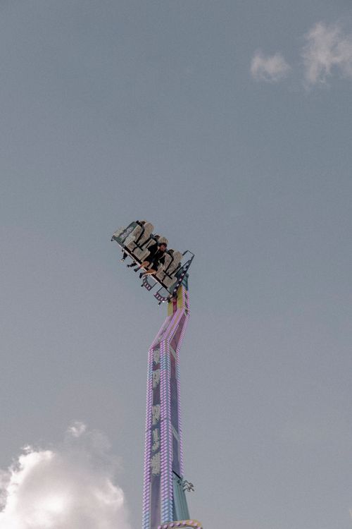 Free An exhilarating ride at a carnival ascends high into the sky, creating a thrilling experience for visitors. Stock Photo