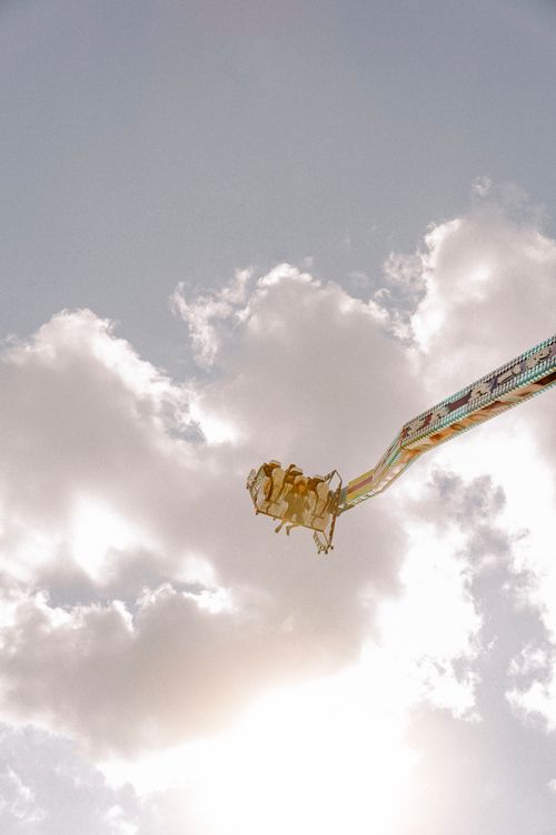 Free Experience the excitement of a high-flying amusement park ride under a bright sky. Stock Photo
