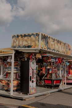 Vintage arcade games at an outdoor fairground with plush toys and nostalgic vibes.