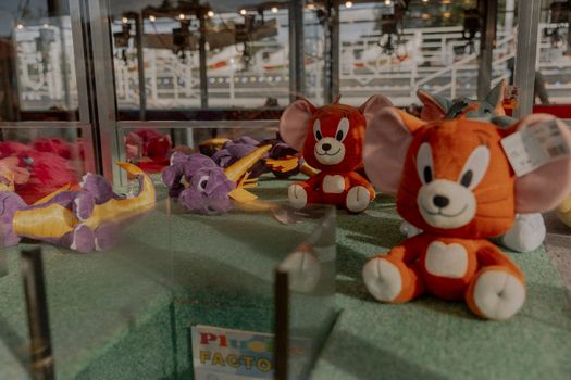Vibrant plush toys including dragons and mice in an urban shop display. Perfect for toy enthusiasts.