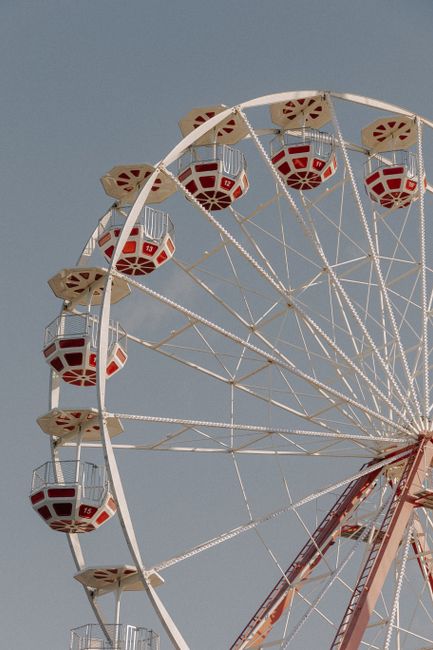 A majestic Ferris wheel captured in a vertical shot, set against a clear blue sky.
