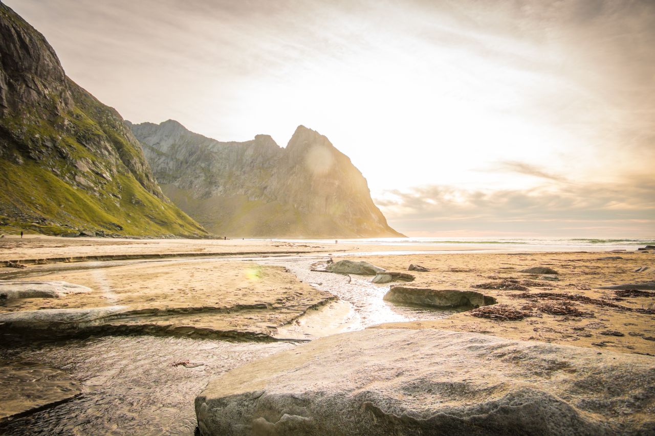 beautiful serene coastline at sunrise with rugged mountains and sandy