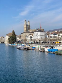 Discover the iconic Grossmünster by the river in Zürich's vibrant cityscape, perfect for travel and architecture lovers.