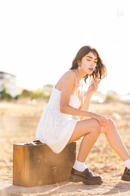 Woman in White Sundress Sitting with Cigarette