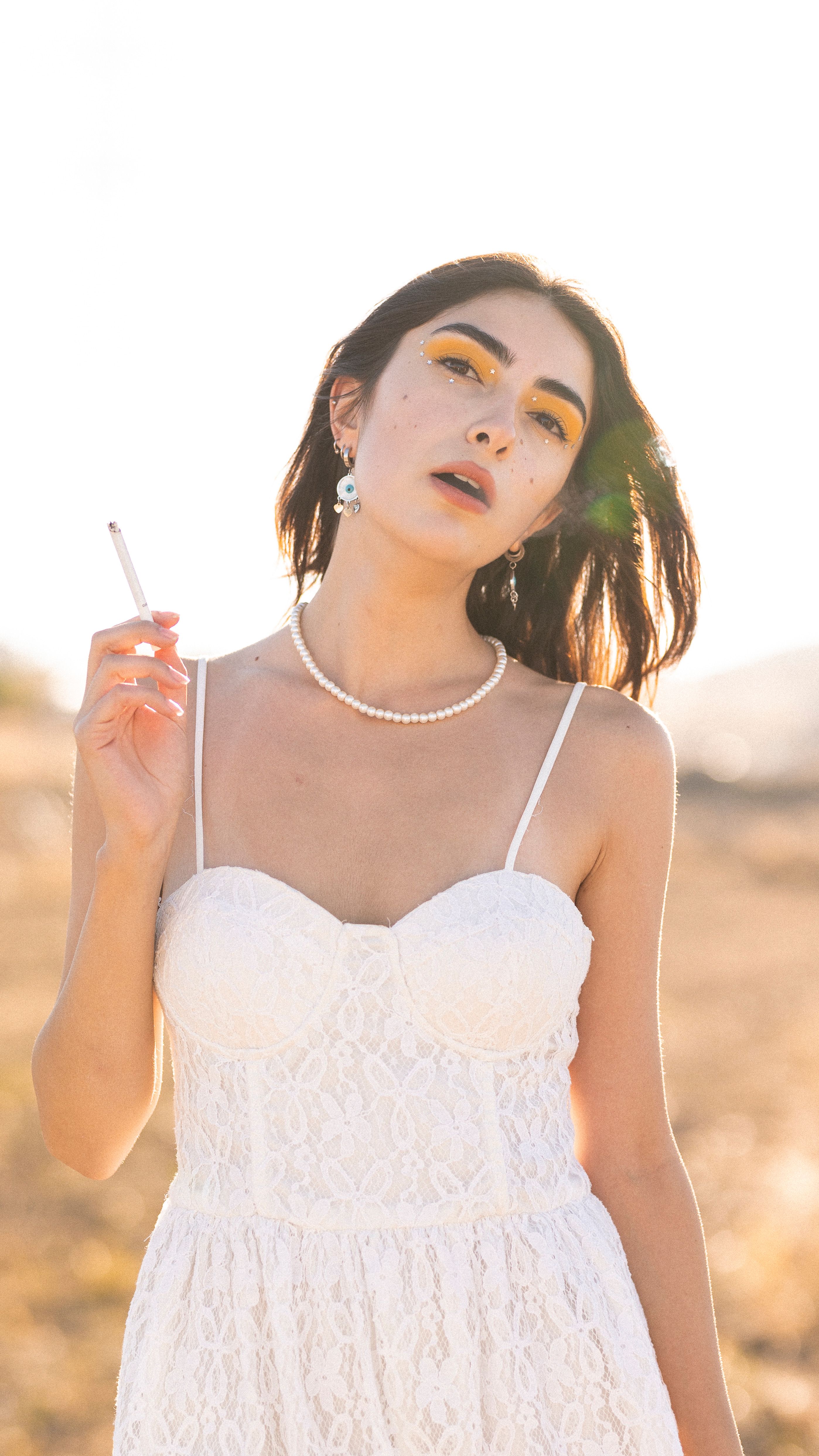 Model in White Dress Smoking Cigarette · Free Stock Photo