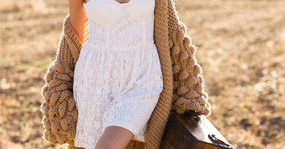 Woman in White Lace Mini Dress and Brown Knot Cardigan Posing with a Vintage Wooden Suitcase Free Stock Photo Woman in White Lace Mini Dress and Brown Knot Cardigan Posing with a Vintage Wooden Suitcase Free Stock Photo