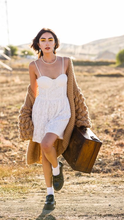 Woman in White Lace Mini Dress and Brown Knot Cardigan Posing with a Vintage Wooden Suitcase Free Stock Photo Woman in White Lace Mini Dress and Brown Knot Cardigan Posing with a Vintage Wooden Suitcase Free Stock Photo