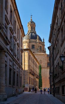 Classic architecture in Salamanca's downtown with a prominent dome and cobbled street.