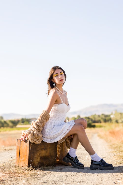 Brunette Woman Posing with Suitcase on Dirt Road