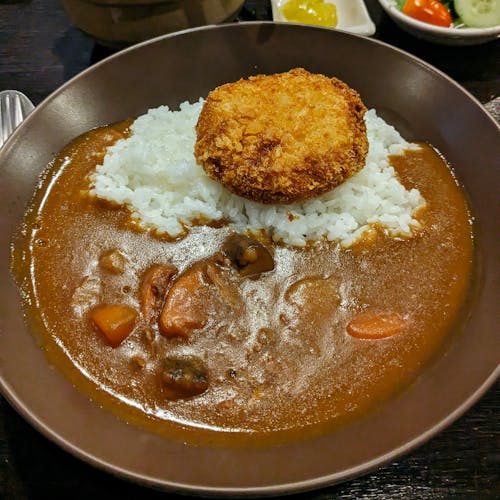 A bowl of curry with rice and a fried egg