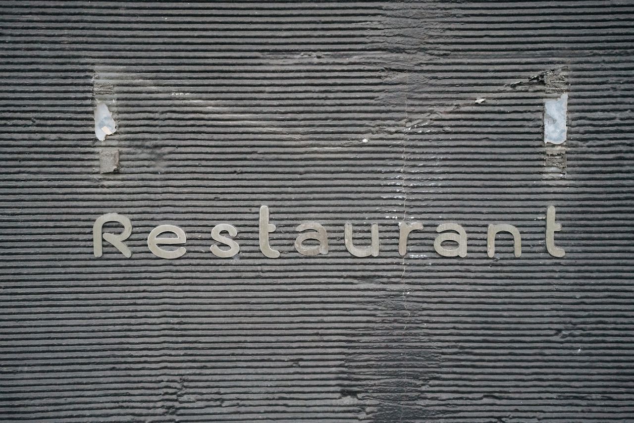 close up of a restaurant sign on a corrugated wall showcasing urban te