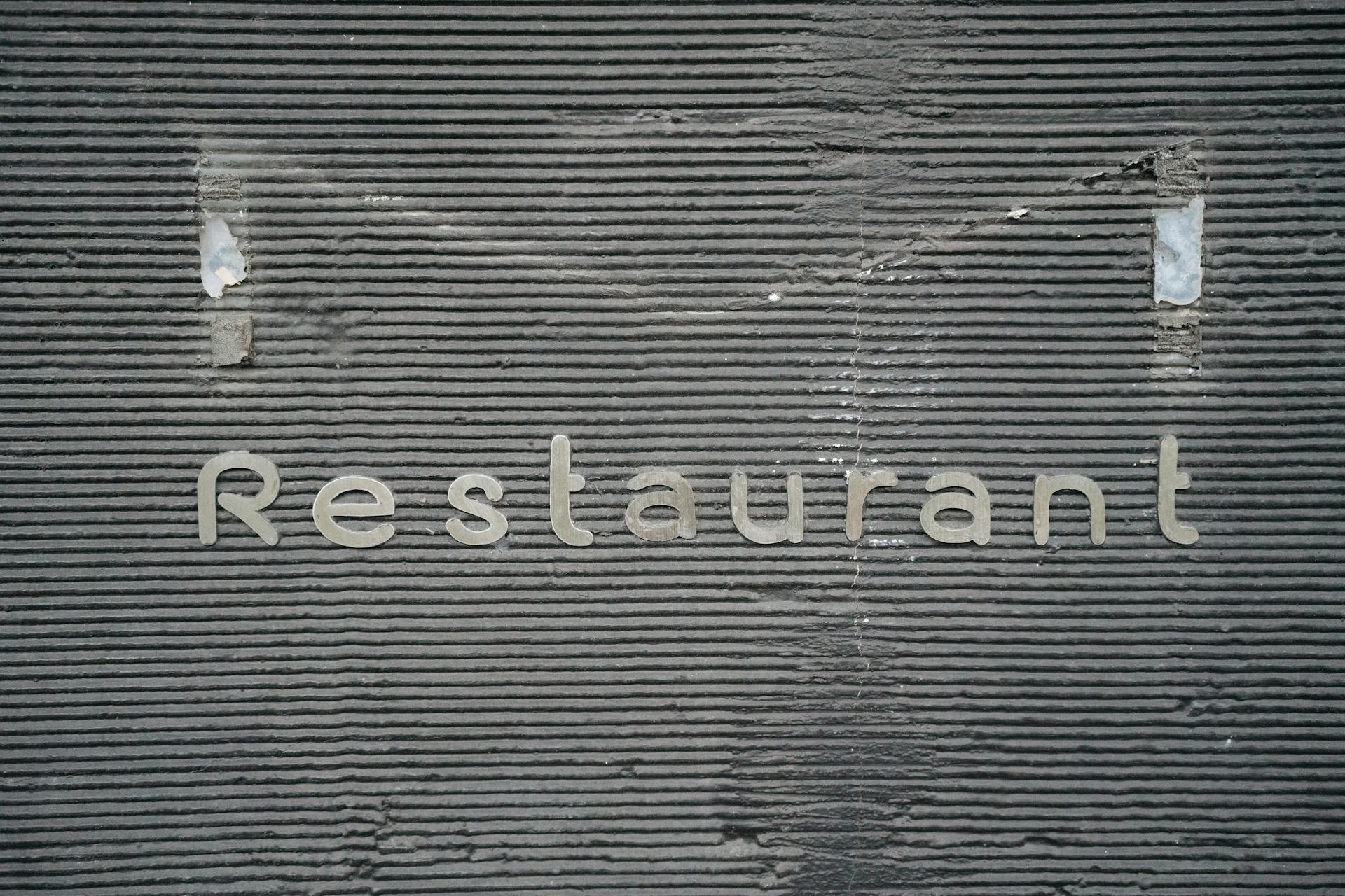 Close-up of a restaurant sign on a corrugated wall, showcasing urban texture and design.