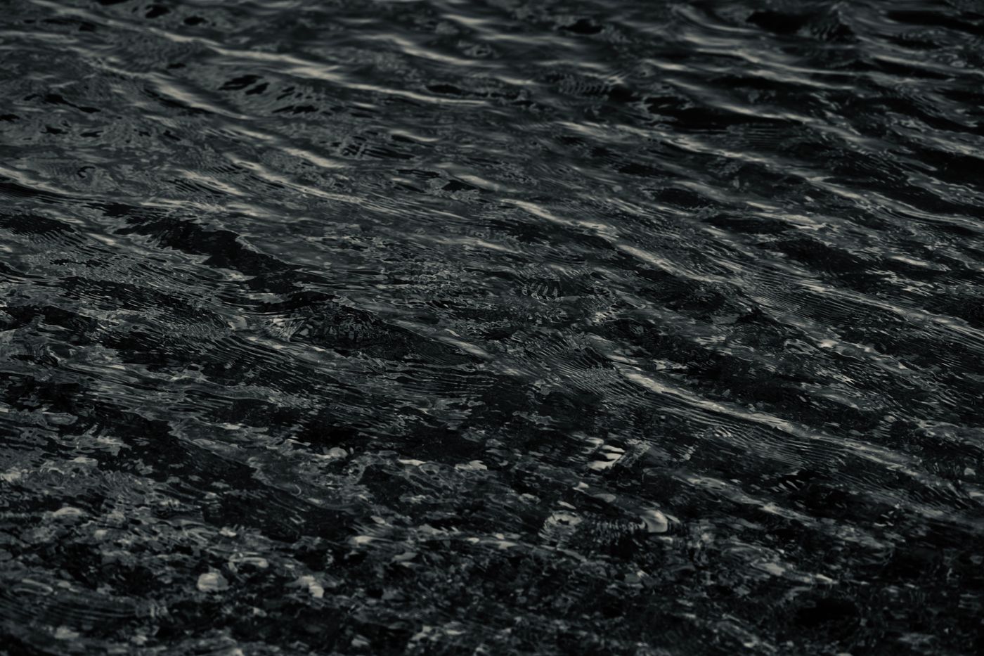 Close view of dark river water breaking into fine ripples — photo by Yanming Guo on Pexels