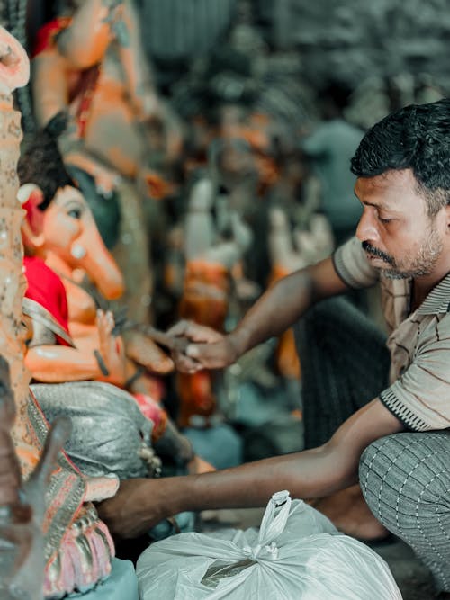 A Man Holding a Ganesh Figurine