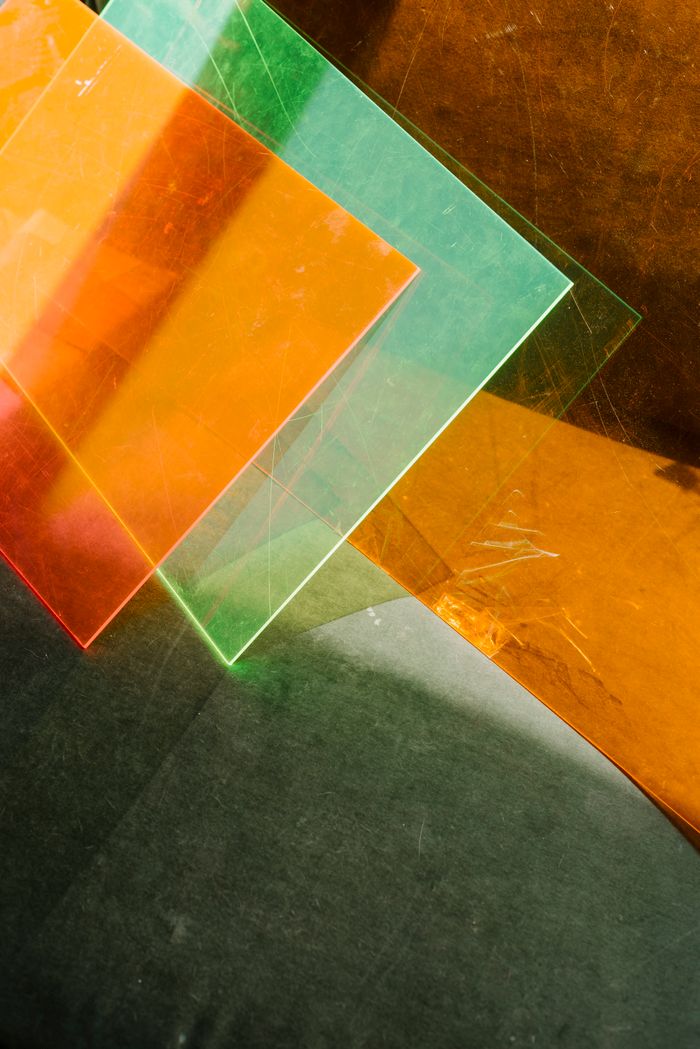 Overlapping translucent orange and green acrylic shapes — photo by Alina Skazka on Pexels