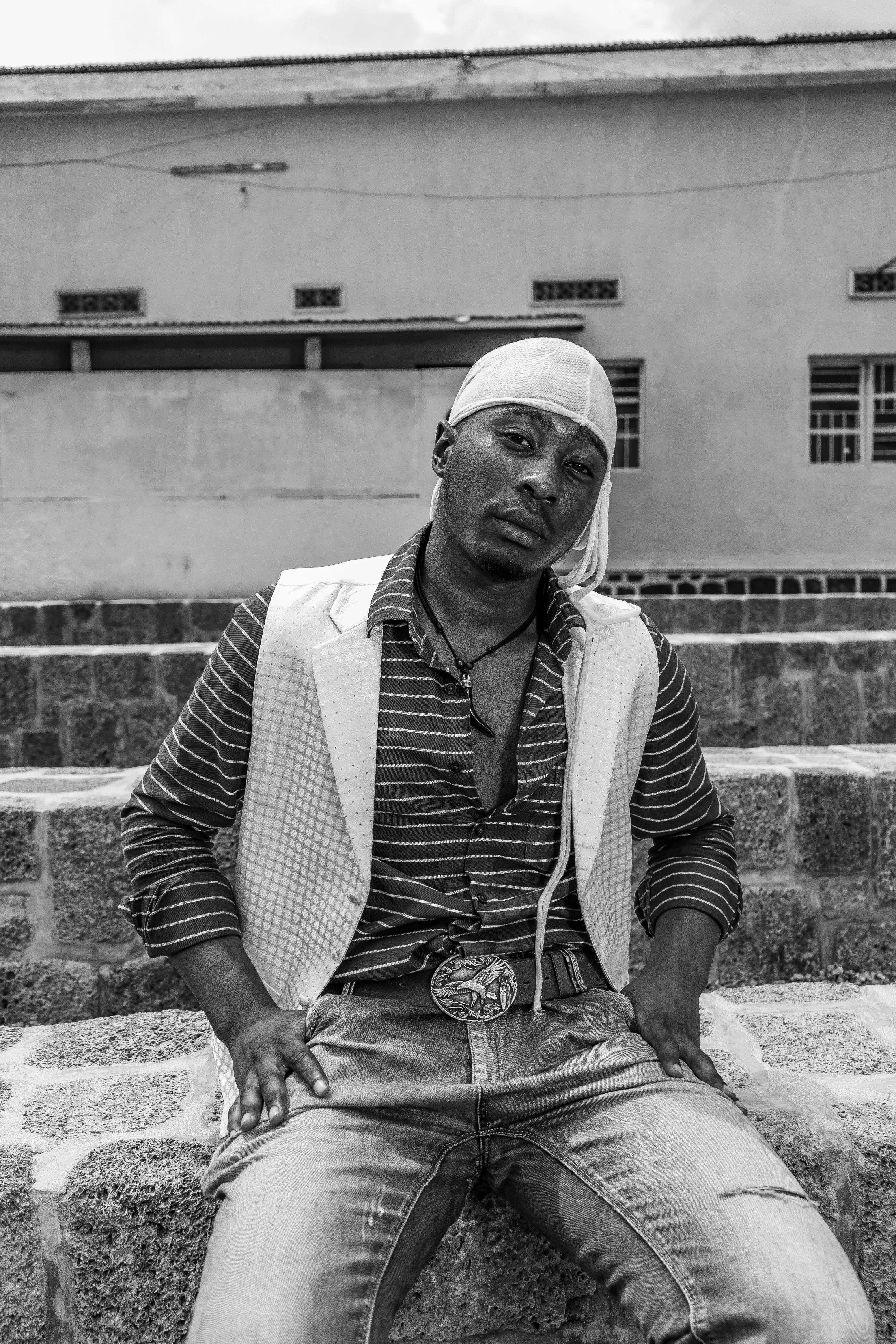 Stylish black and white portrait of a man in urban setting with fashionable attire.