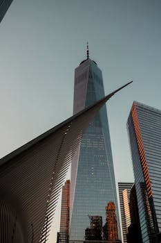 A stunning low angle view of One World Trade Center and the Oculus in New York City at dusk.