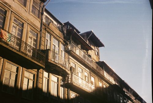 Free A historic building in Porto, Portugal with intricate balconies and sunlight reflections. Stock Photo