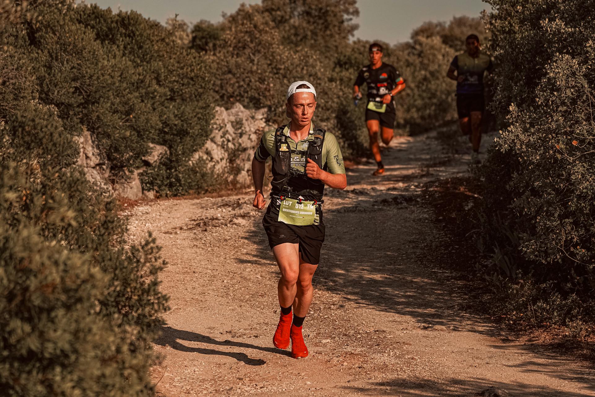 Group of runners participating in an outdoor trail race on a sunny day.