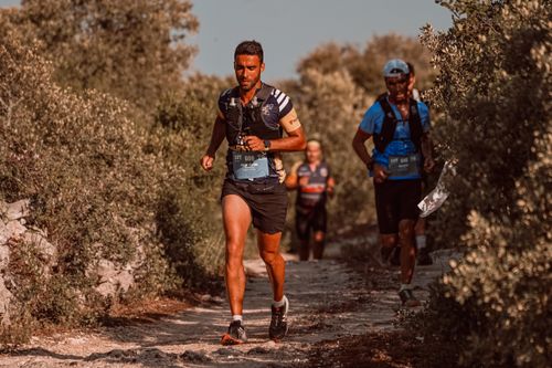 Free Three male athletes running a challenging trail marathon outdoors in summer. Stock Photo