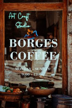 Window display at Borges Coffee in Ankara with fresh vegetables, reflections, and café ambiance.