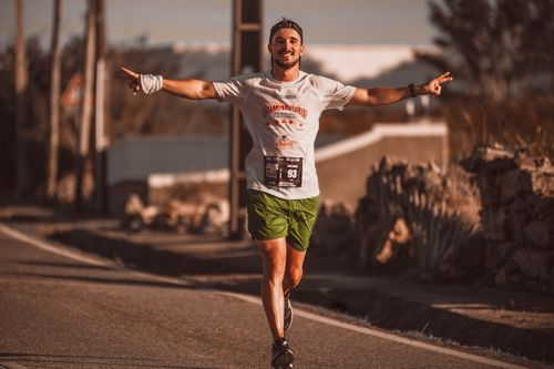 Free Smiling runner enjoys the thrill of a marathon on a sunny day outdoors. Stock Photo