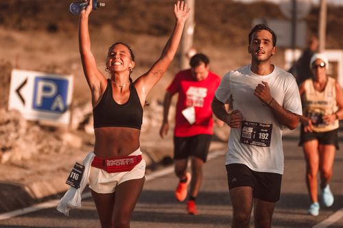 Free Marathon participants celebrating victory with joyful expressions on a sunny day. Stock Photo