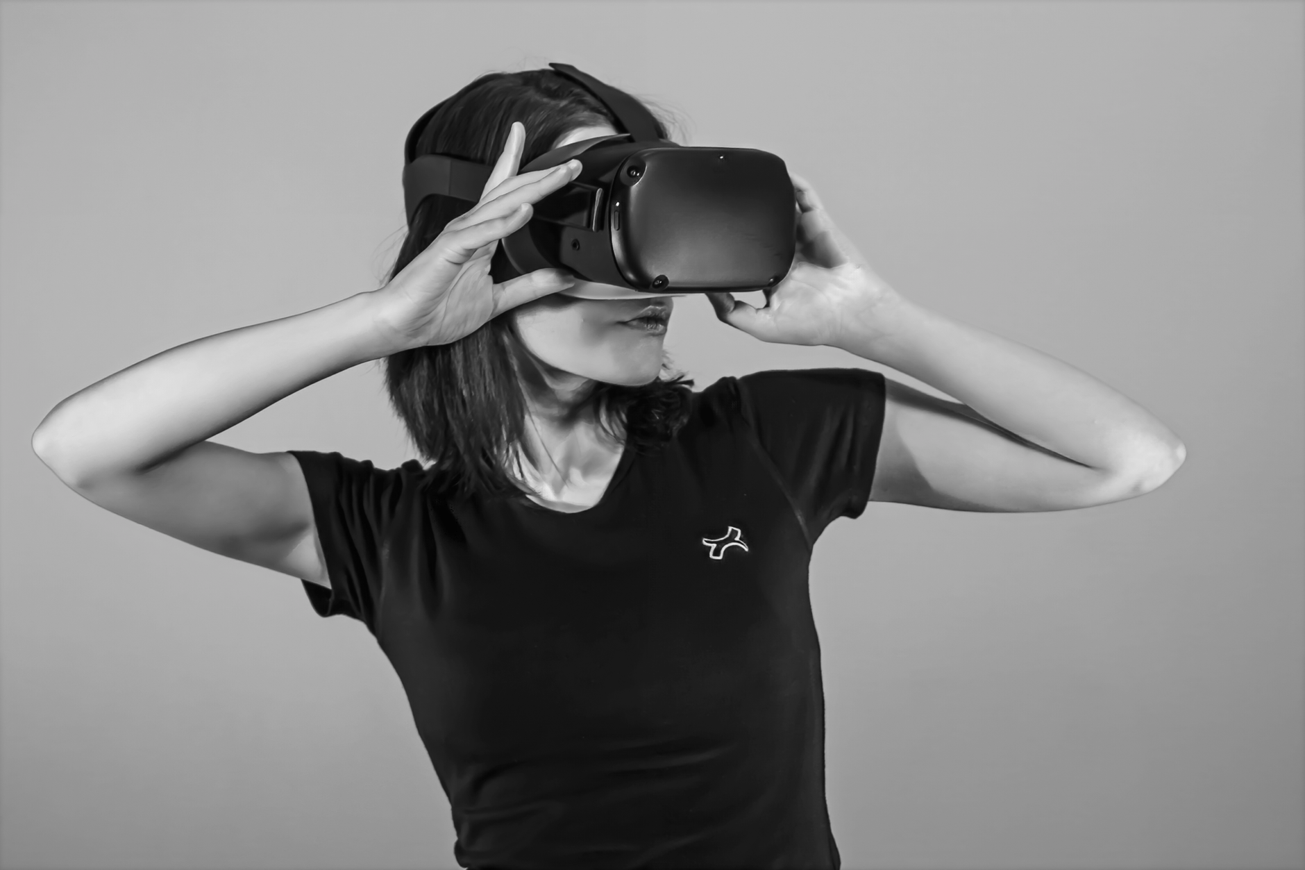 Black and white portrait of a young woman using a VR headset.