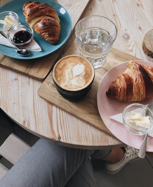 Free Coffee and Croissants Placed on Wooden Table Top  Stock Photo