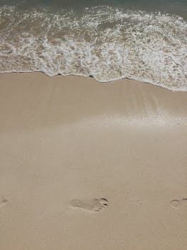 在多米尼加共和国的沙滩上，宁静的海滩场景中，温柔的海浪边留下了脚印