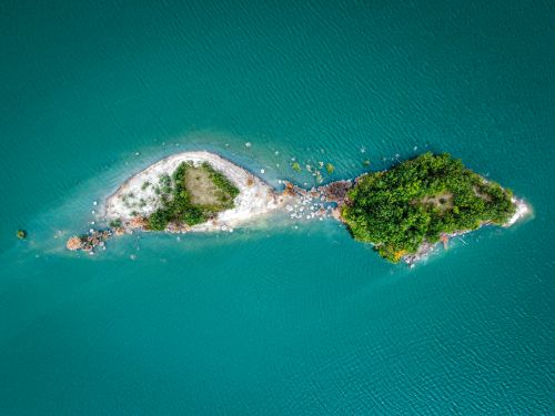 Free Stunning drone shot of two lush islands in turquoise water, offering a vibrant coastal scenery. Stock Photo