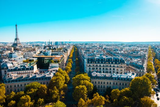 A stunning aerial view of Paris featuring the Eiffel Tower and urban landscape lit by daytime sunshine.