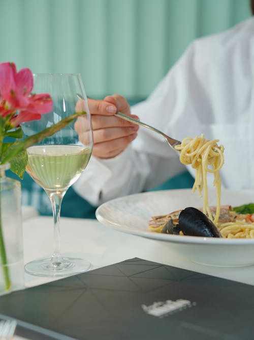 Free Eating Pasta with Mussels in a Sauce of Garlic Butter and White Wine Stock Photo