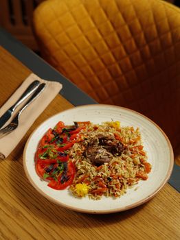 Savory rice dish with fresh tomatoes and succulent meat, perfect for dinner in a cozy setting.