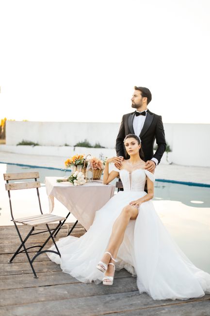 Chic couple posing elegantly by a pool, blending classic and modern wedding style.