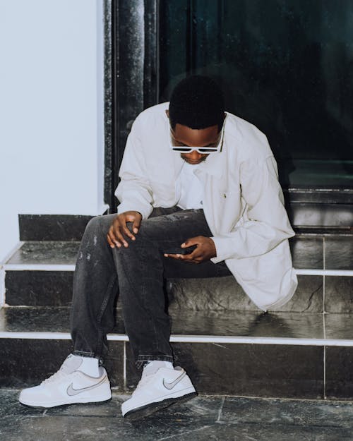 Young Man in a Trendy Outfit Sitting on Steps