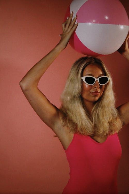 Blonde Woman Holding Ball in Raised Arms