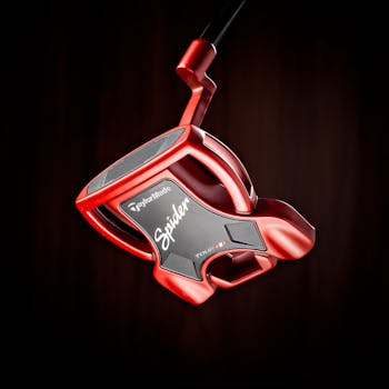 Close-up shot of a red TaylorMade Spider Tour putter against a dark backdrop, highlighting its modern design.