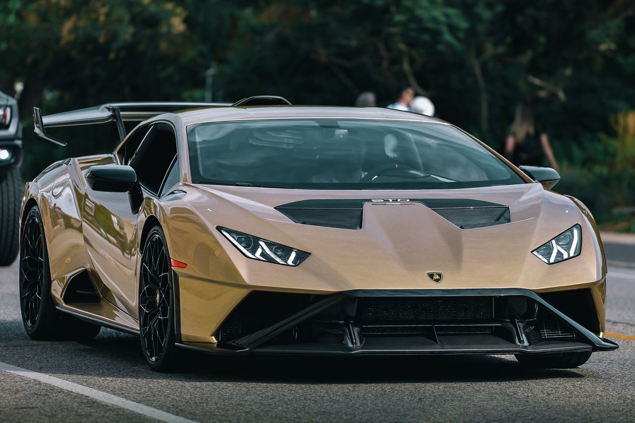 luxurious gold lamborghini huracan supercar parked on an urban street