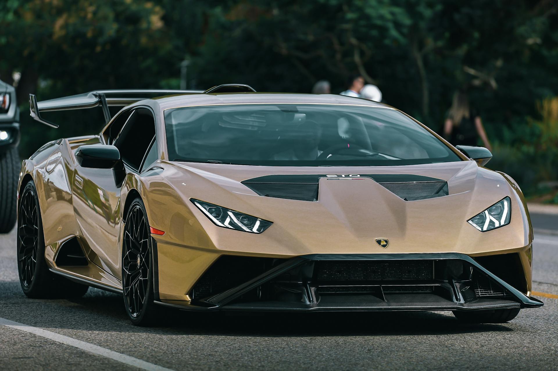 Luxurious gold Lamborghini Huracan supercar parked on an urban street, showcasing its sleek design.