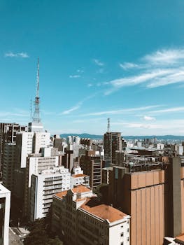 晴朗的蓝天下，现代摩天大楼构成了一幅充满活力的城市景观