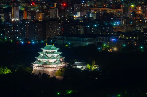 Free Nagoya Castle glowing amidst the city lights of Nagoya, Japan, captured at night. Stock Photo