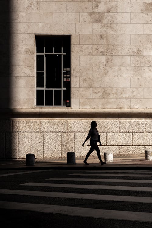 Silhouette of Pedestrian on Sidewalk in City