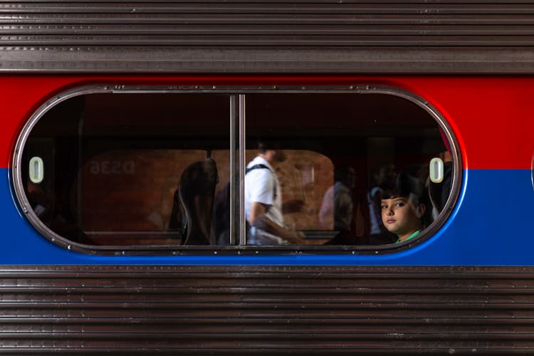 A Boy Sitting Inside The Train