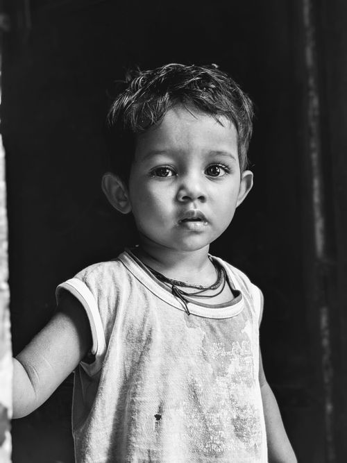 Free A touching black and white portrait capturing the innocence of a young child looking contemplative. Stock Photo